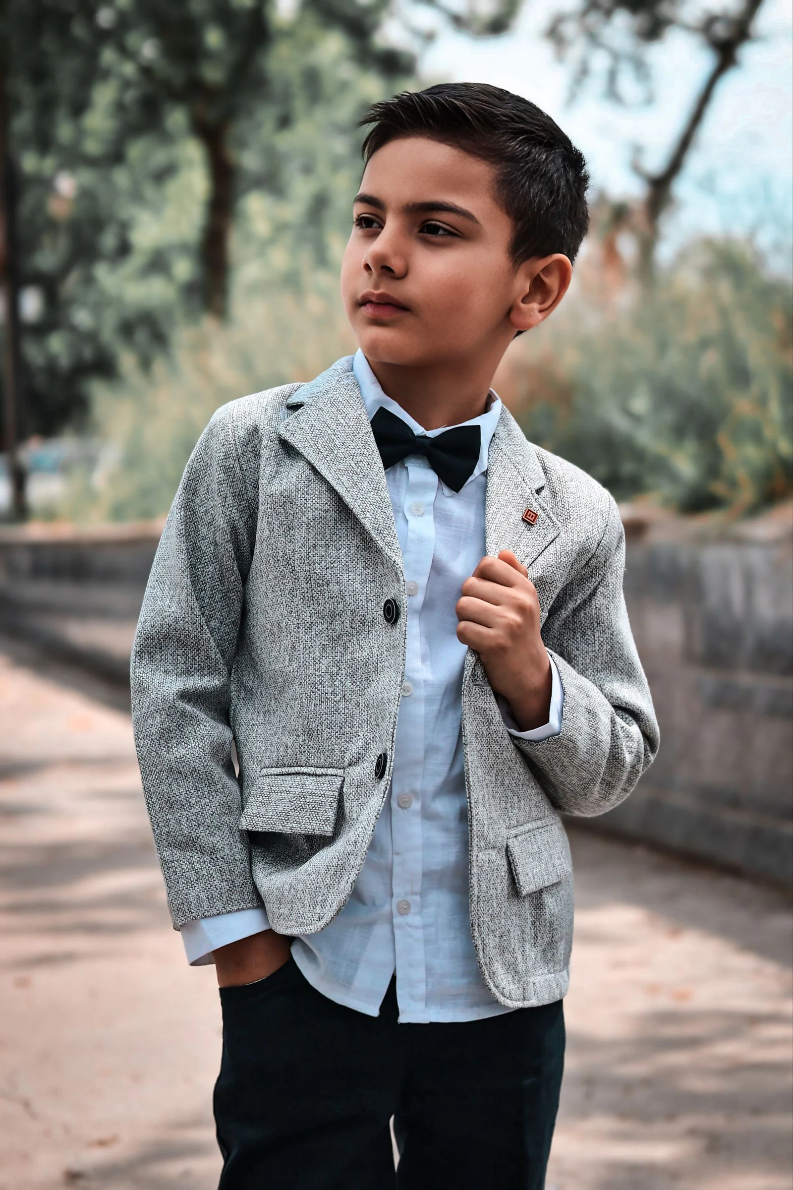 Young boy in stylish gray suit outdoors