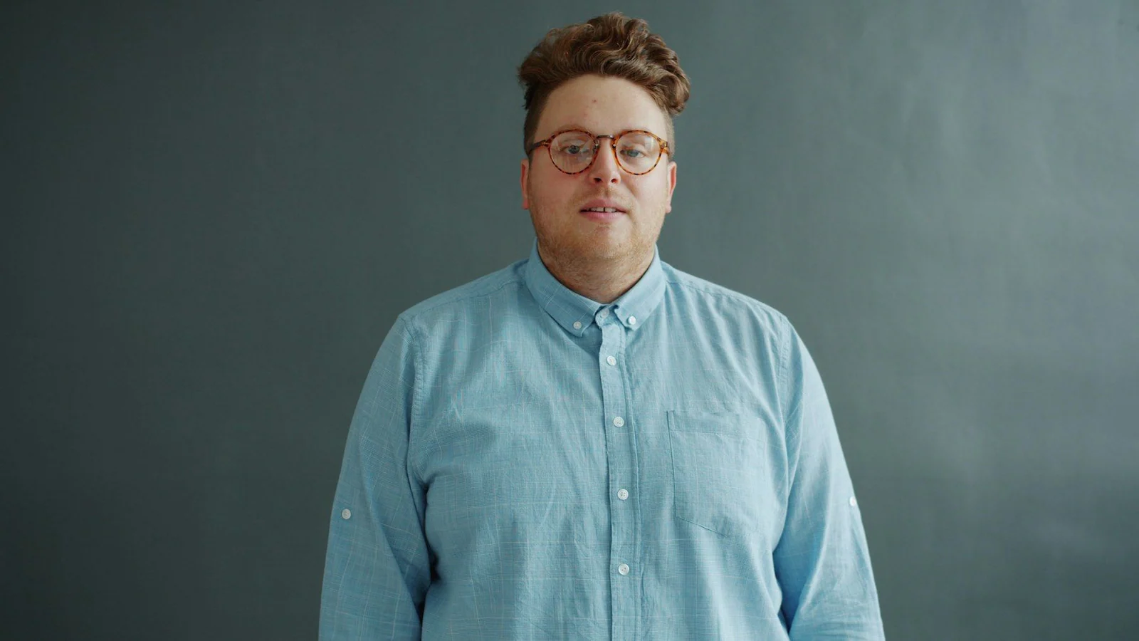 A person wearing a blue shirt and glasses