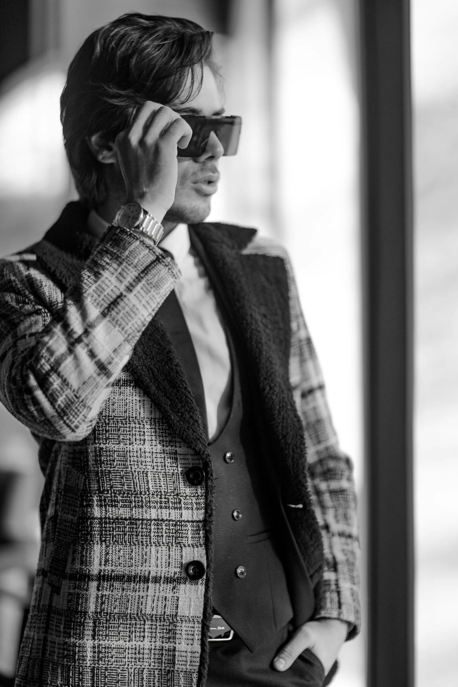 Man in black and white plaid button up shirt and black sunglasses