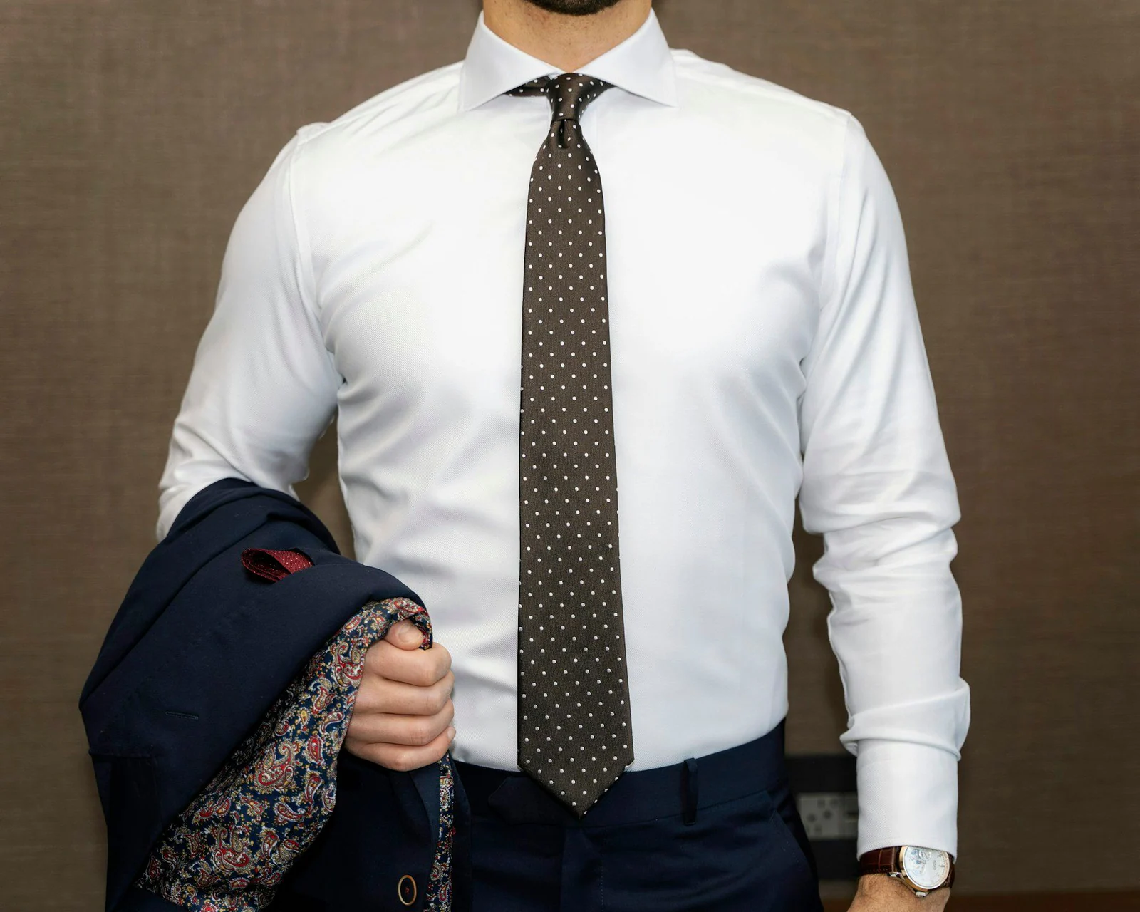 Man in white dress shirt with black and white polka dots necktie