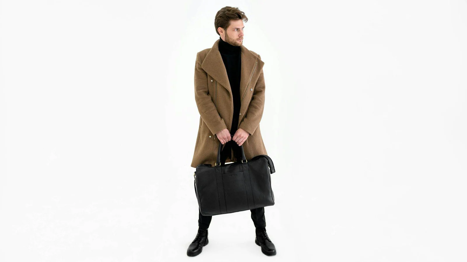 Man in a camel overcoat carrying a leather bag