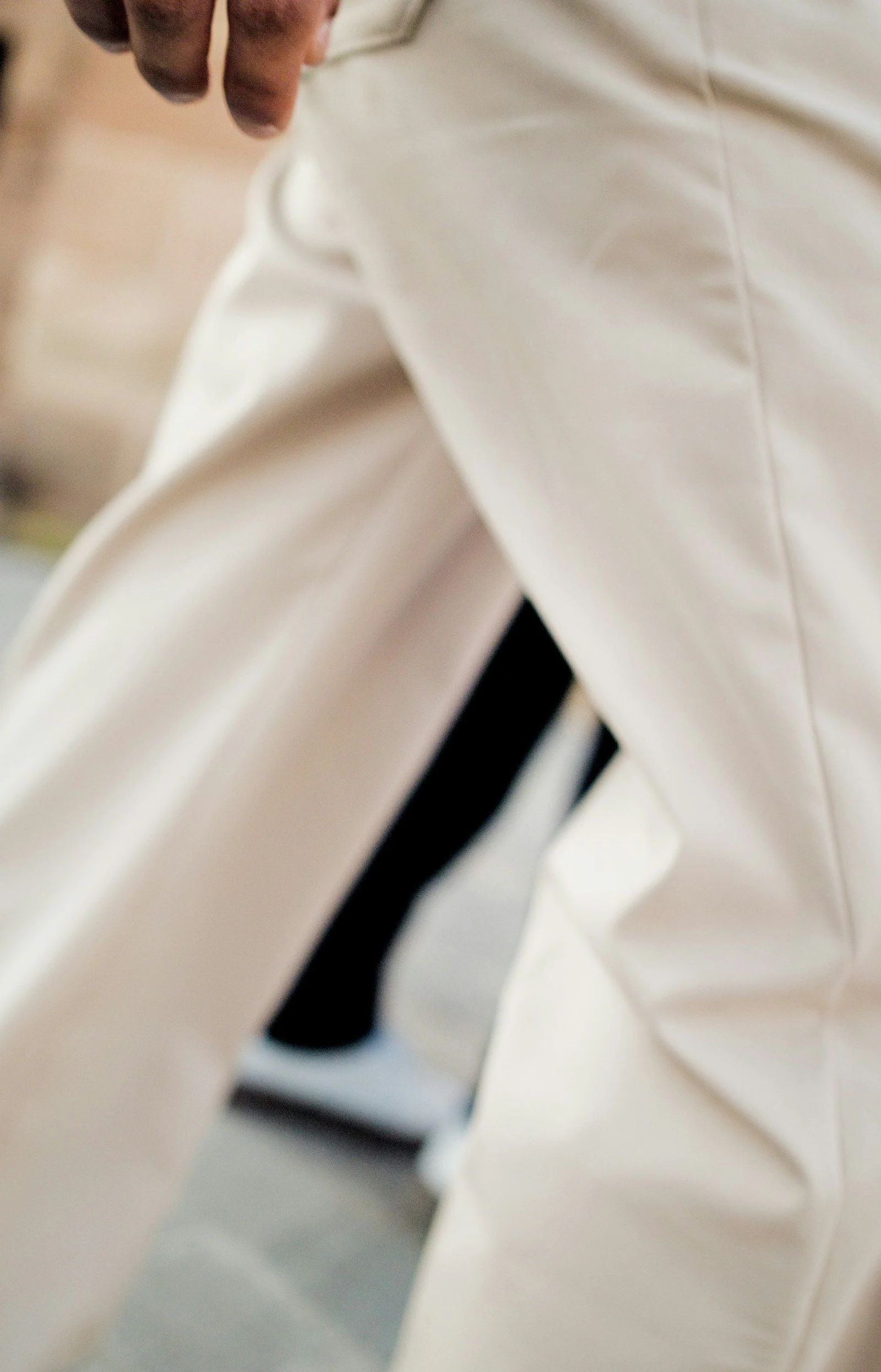 A person wearing light colored pants and white sneakers