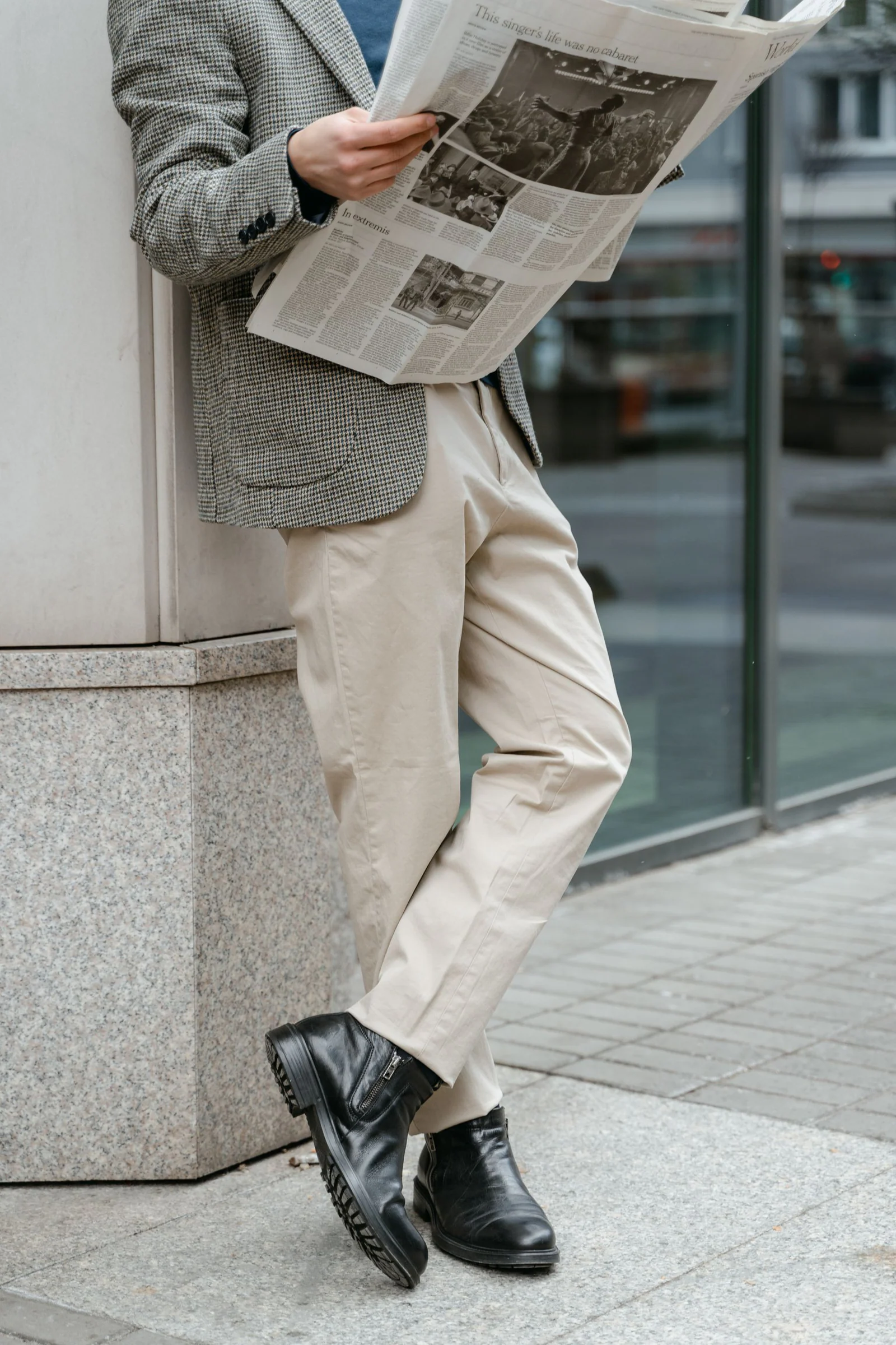 A person in business attire reading a newspaper