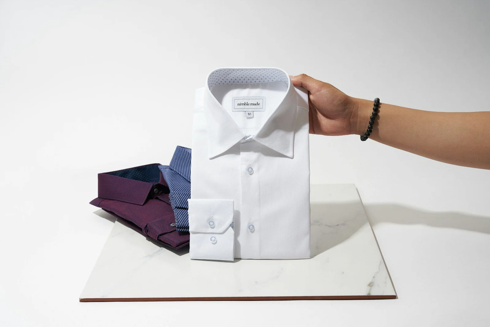Person holding white button up shirt