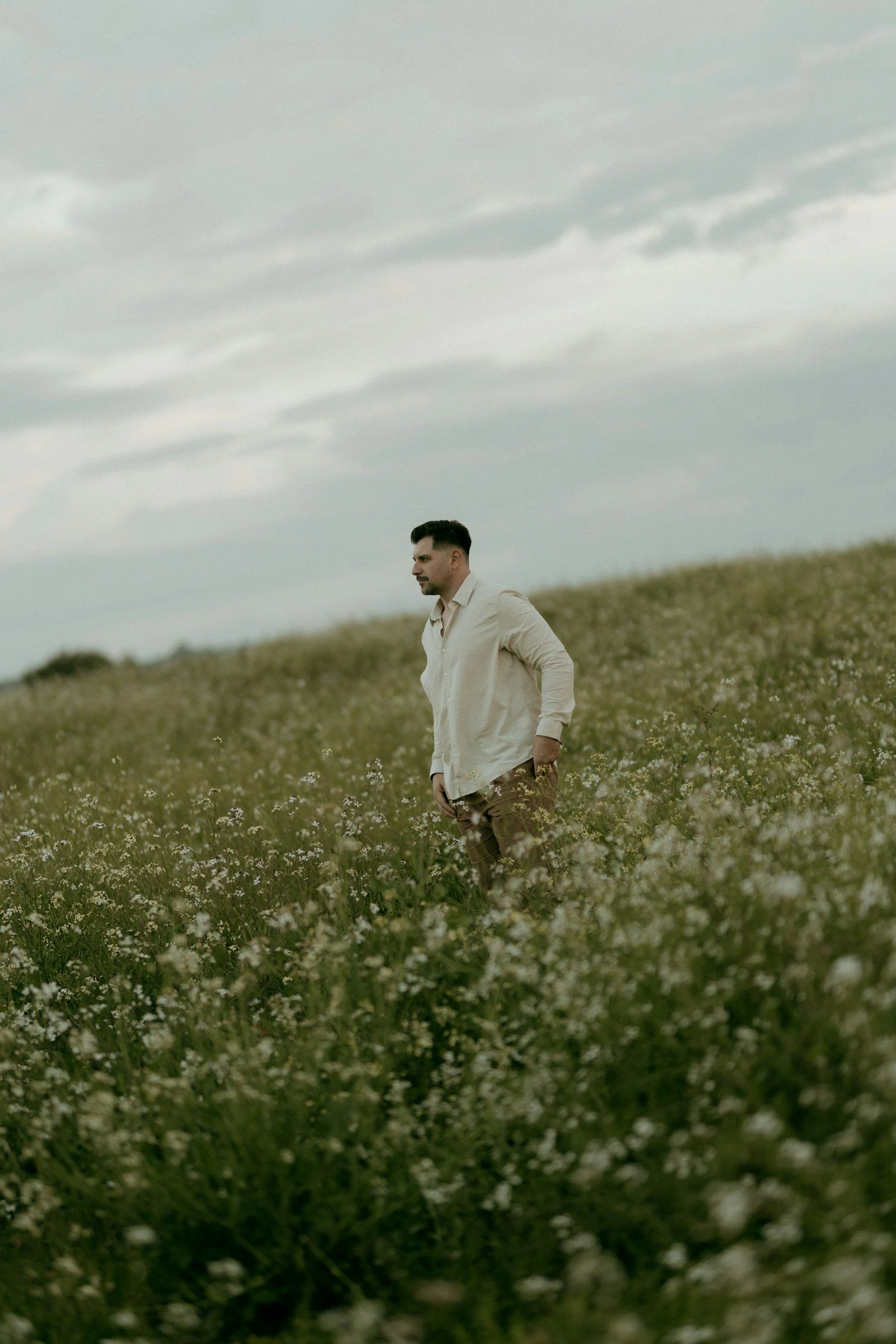 A man stands in a field of white flowers