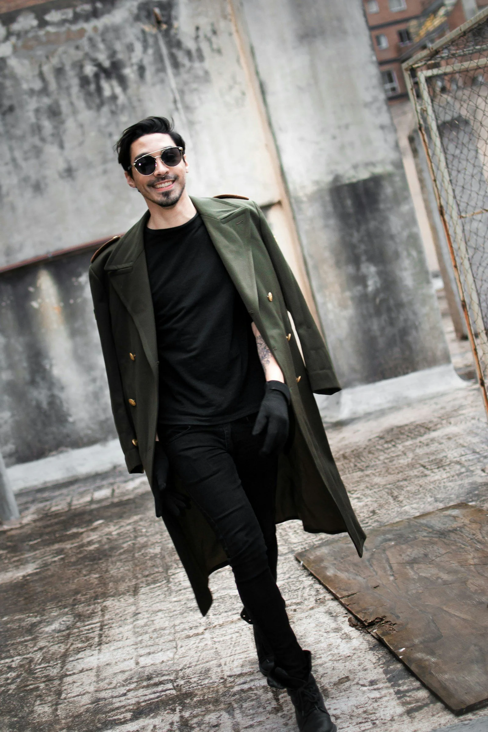 A man in a black shirt and green coat