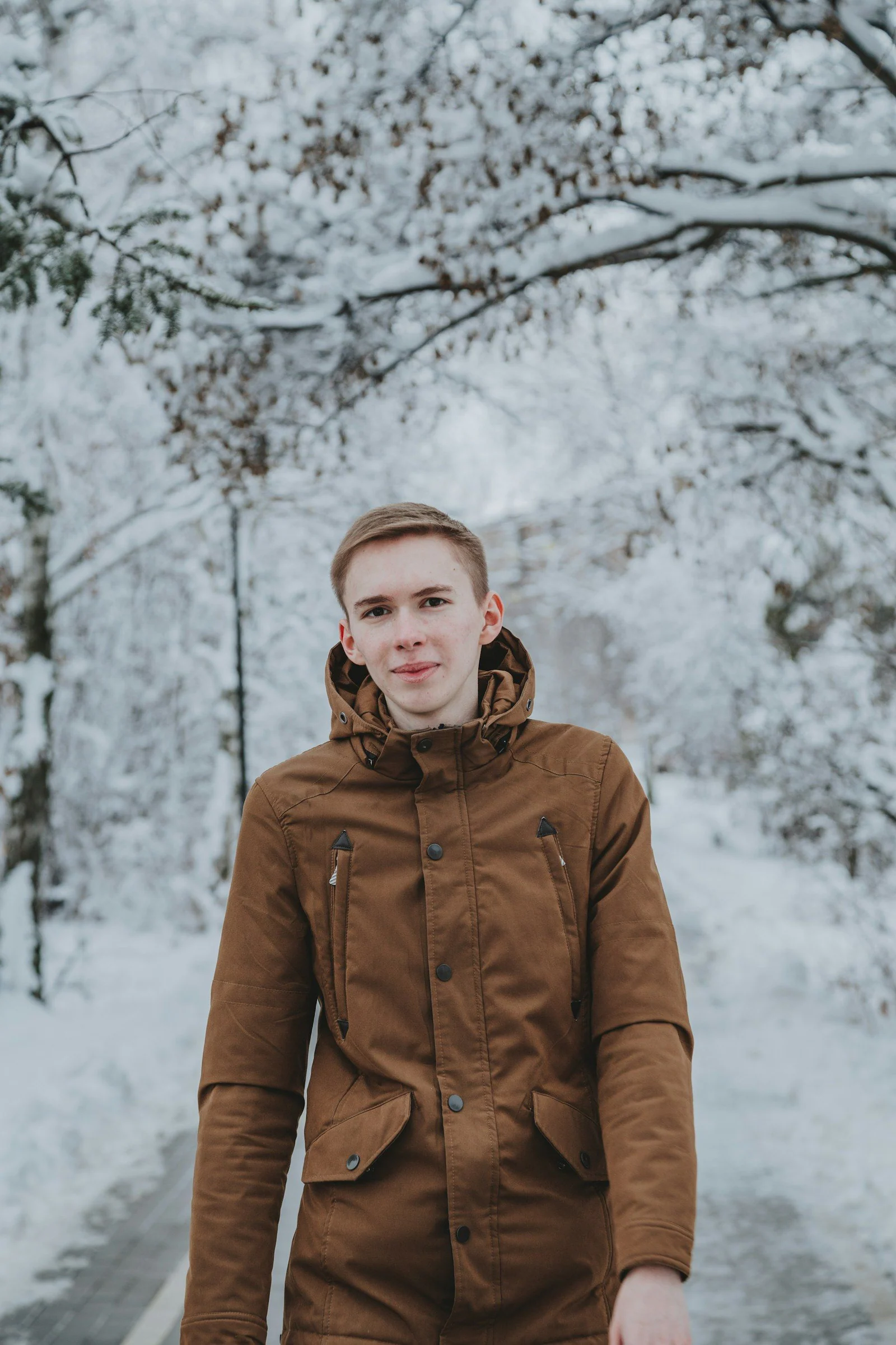 Man in brown zip up jacket standing on snow covered ground during daytime