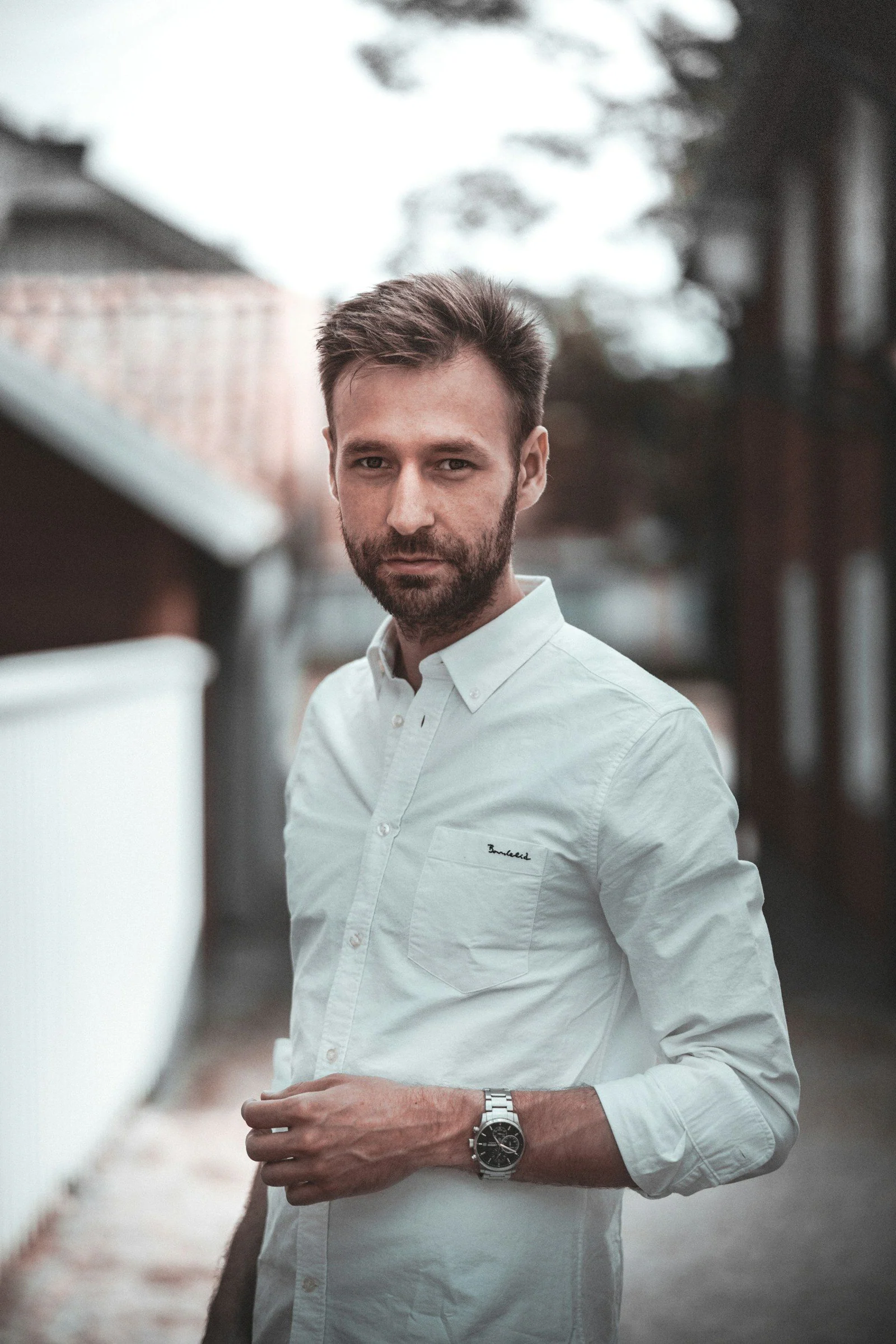 A man in a white shirt is posing for a picture