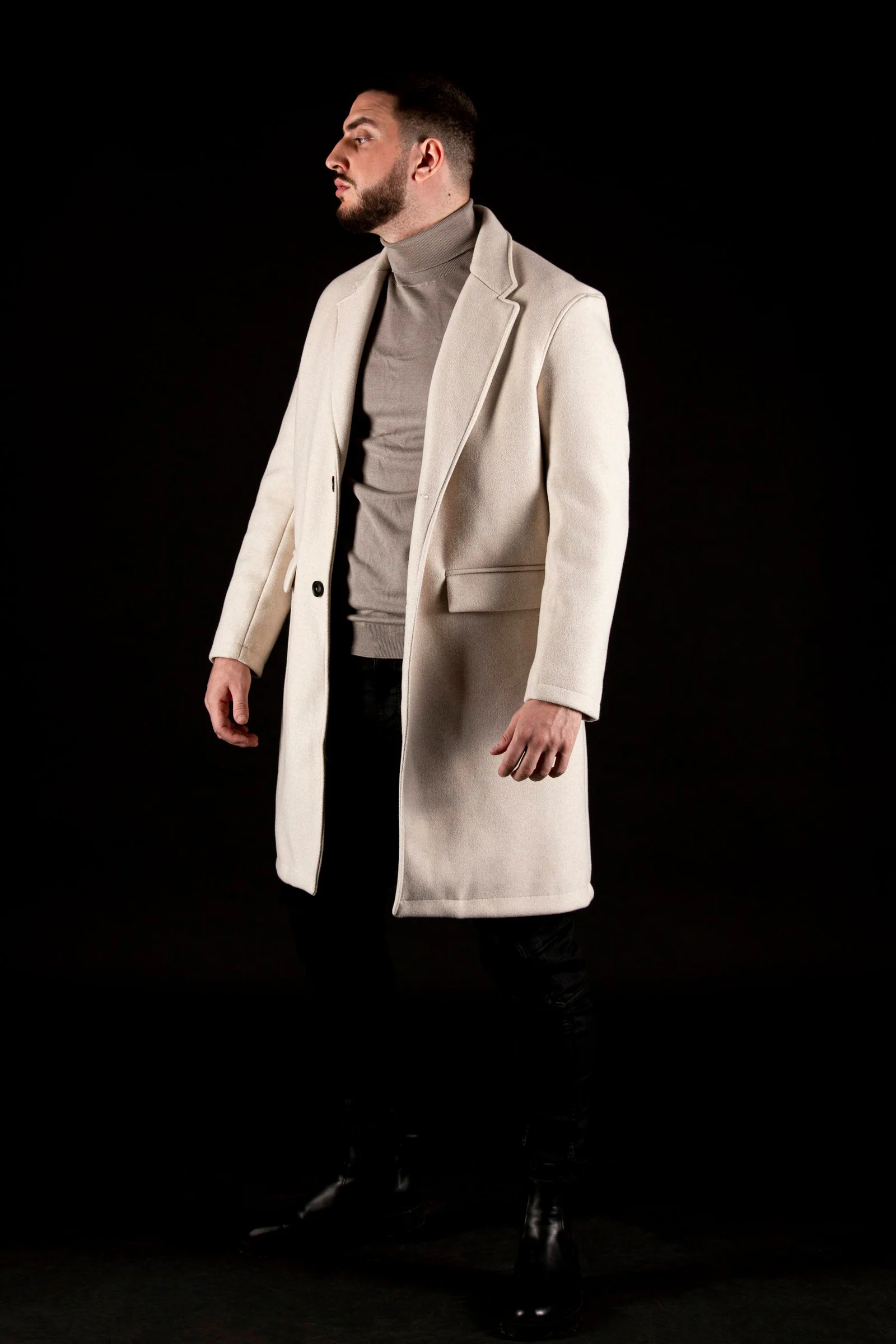 A man in a white coat and black pants
