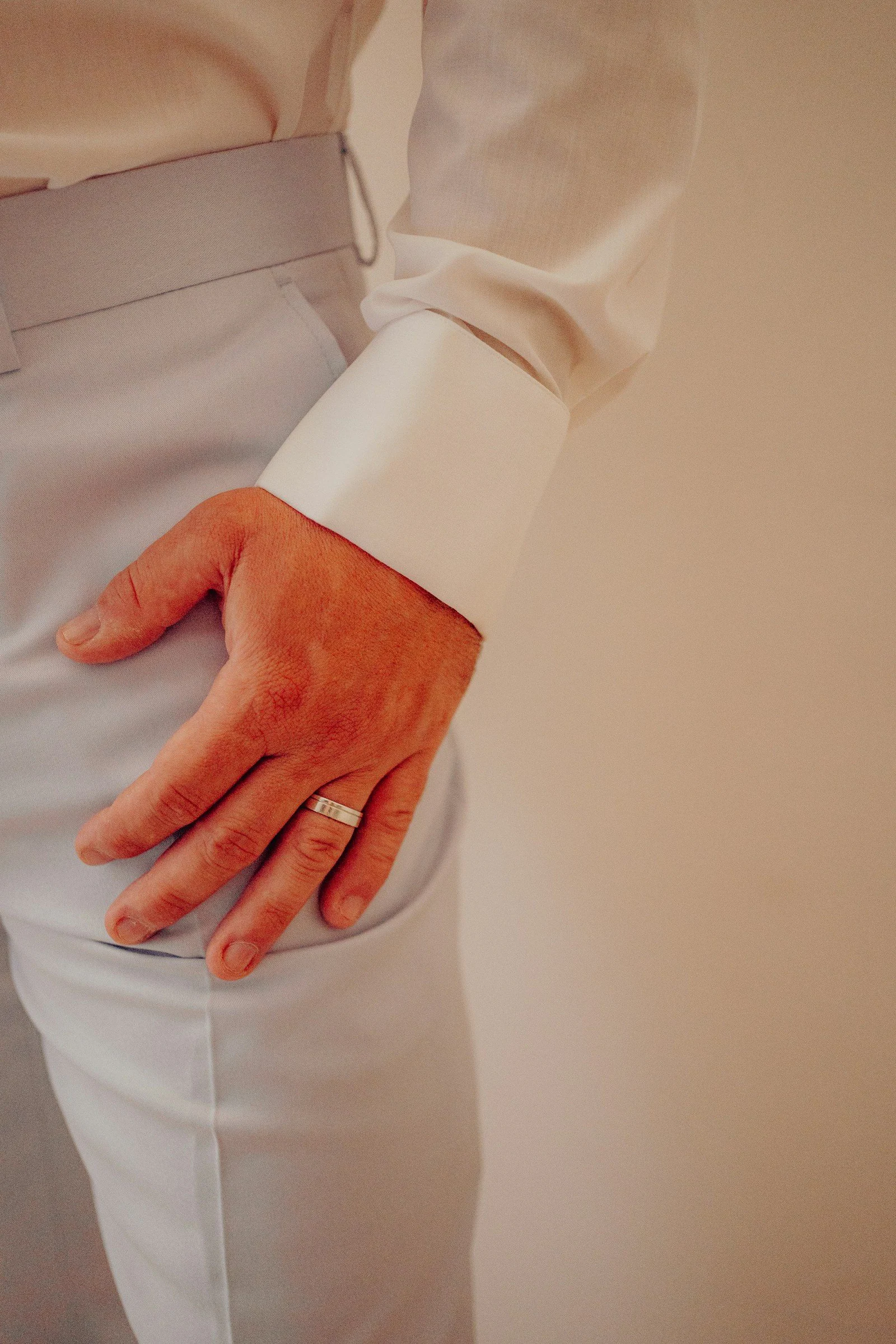 A mans hand with a ring on his hip