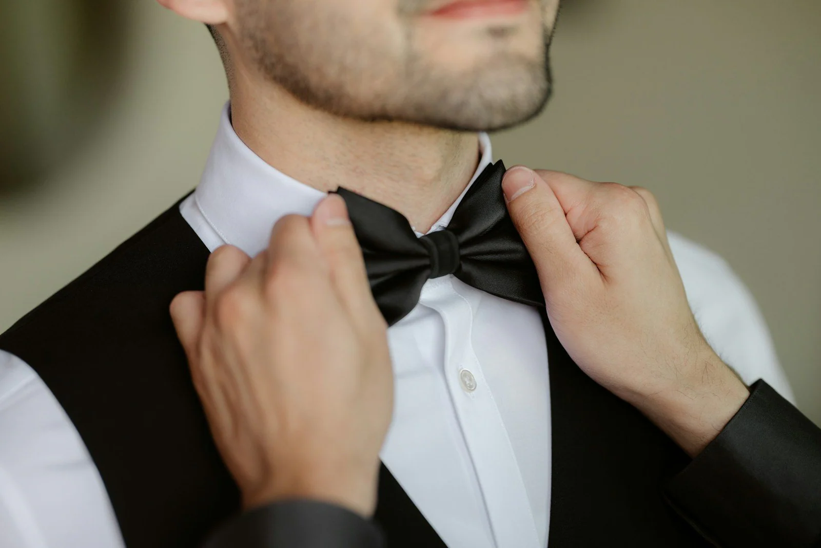 A man adjusts his bow tie