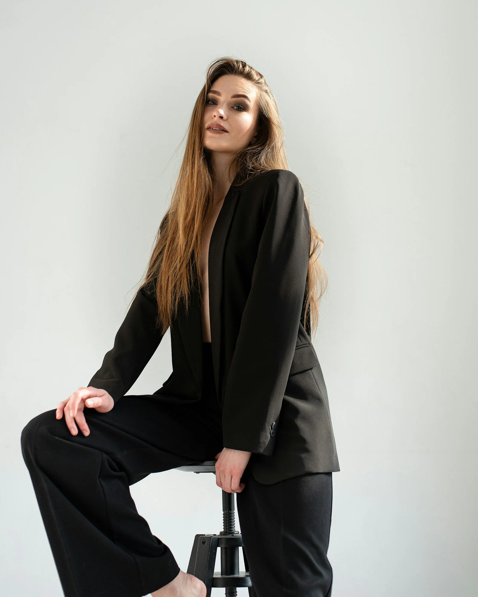 A woman sitting on a stool with her legs crossed