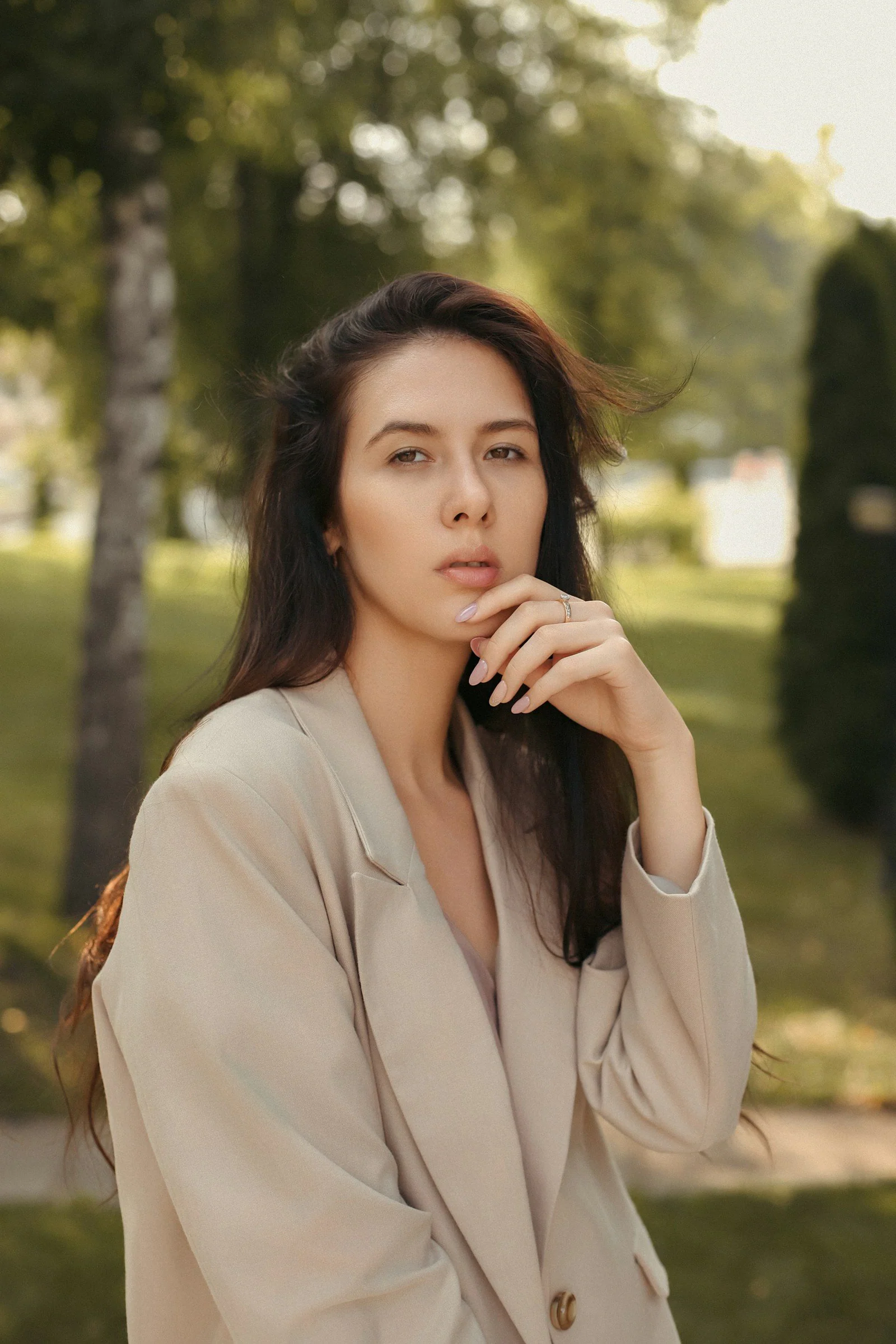 A woman in a beige suit posing for a picture
