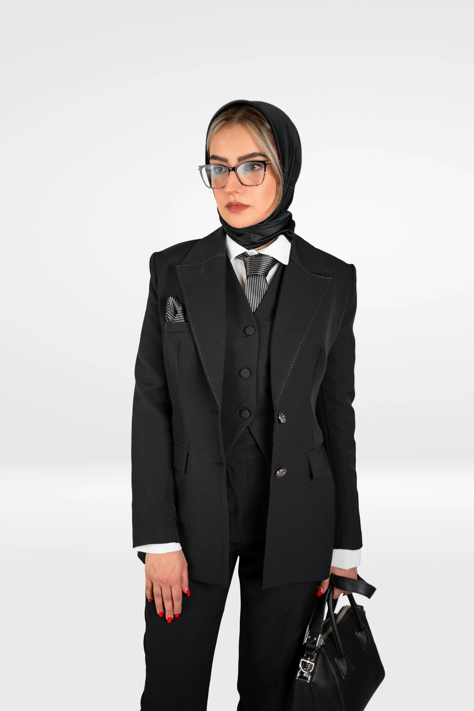A woman in a tuxedo holding a purse