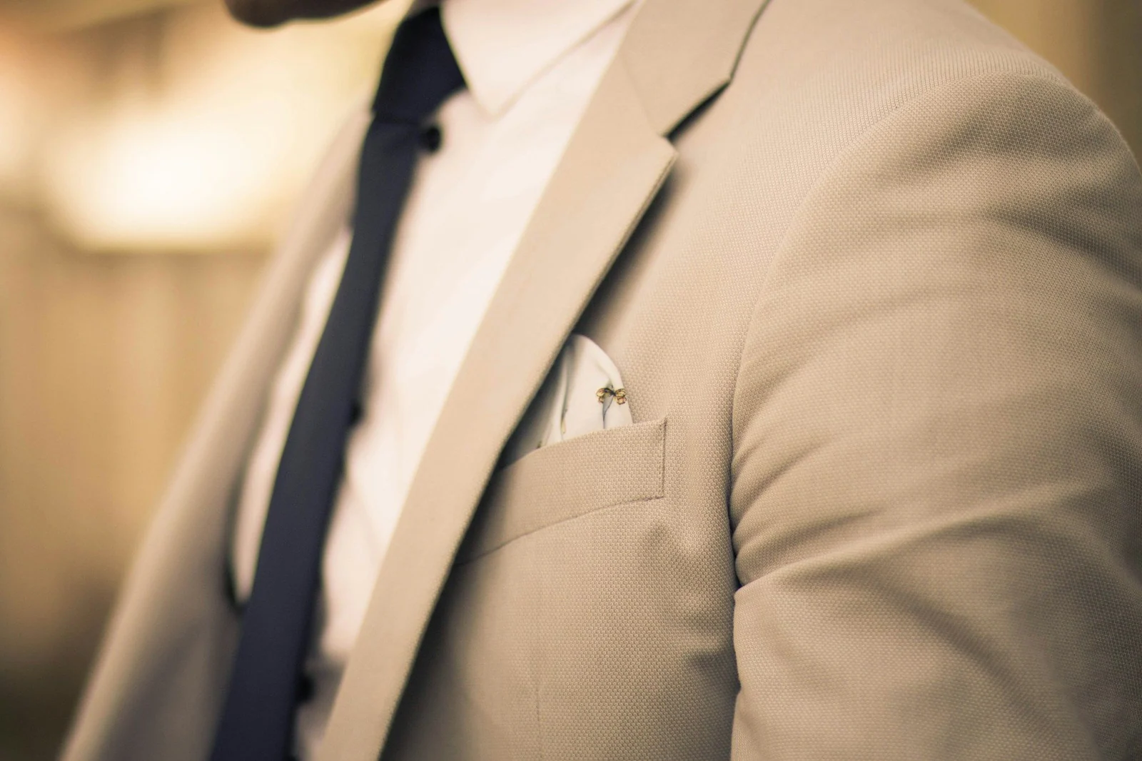 Close-up of a beige jacket lapel and pocket square