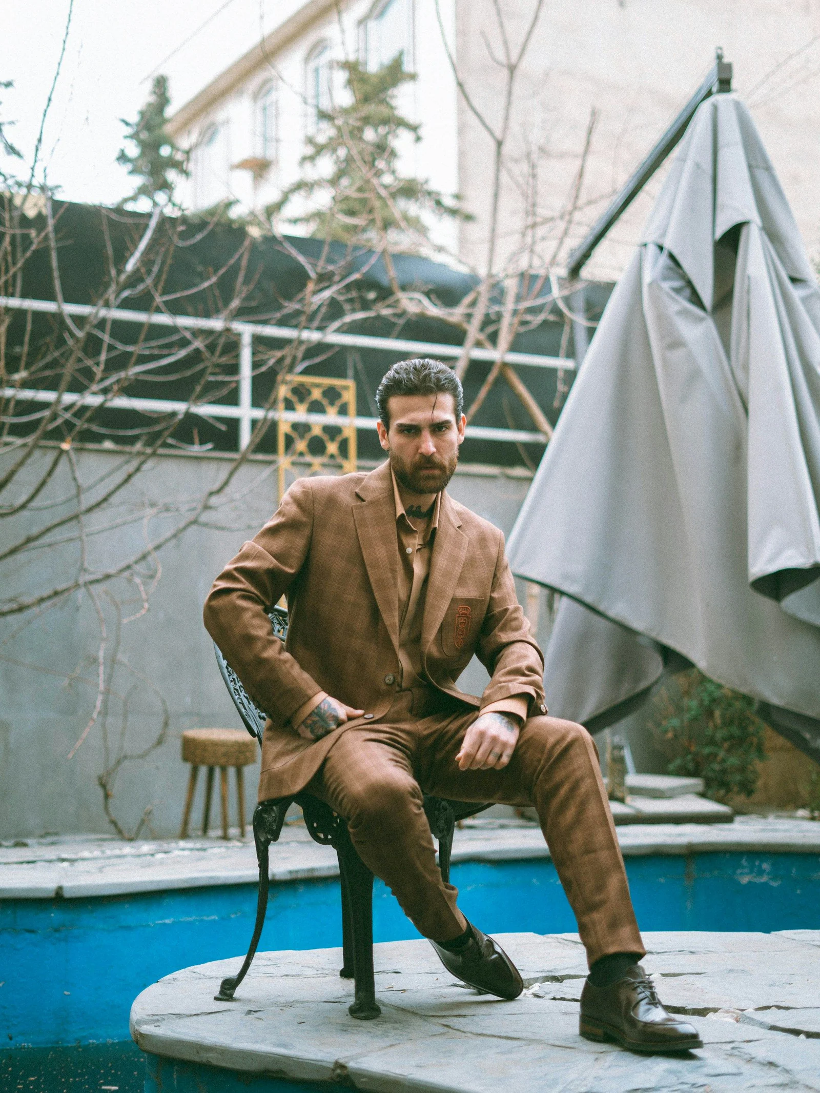 Tan summer suit, seated by a swimming pool