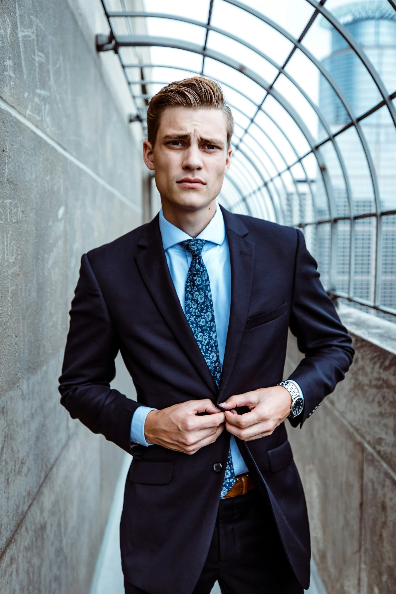 Man in a navy two-piece suit with a teal tie