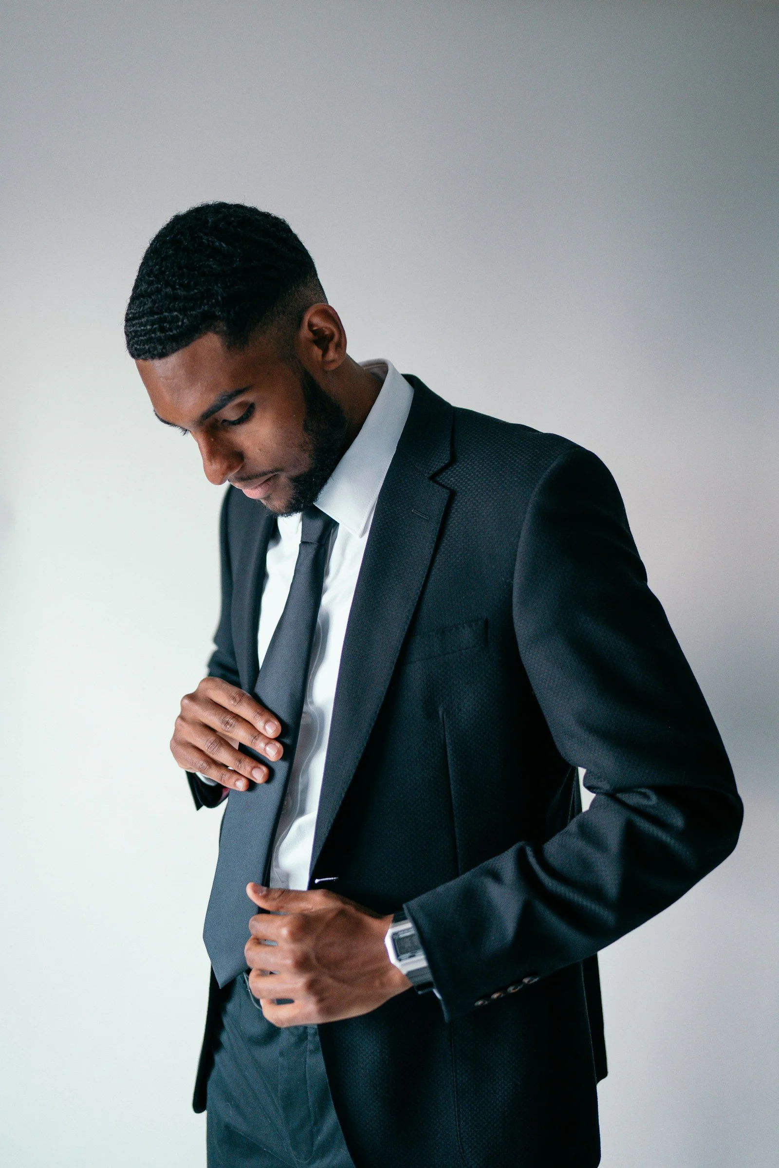 Black two-piece suit worn with a white shirt and slim tie