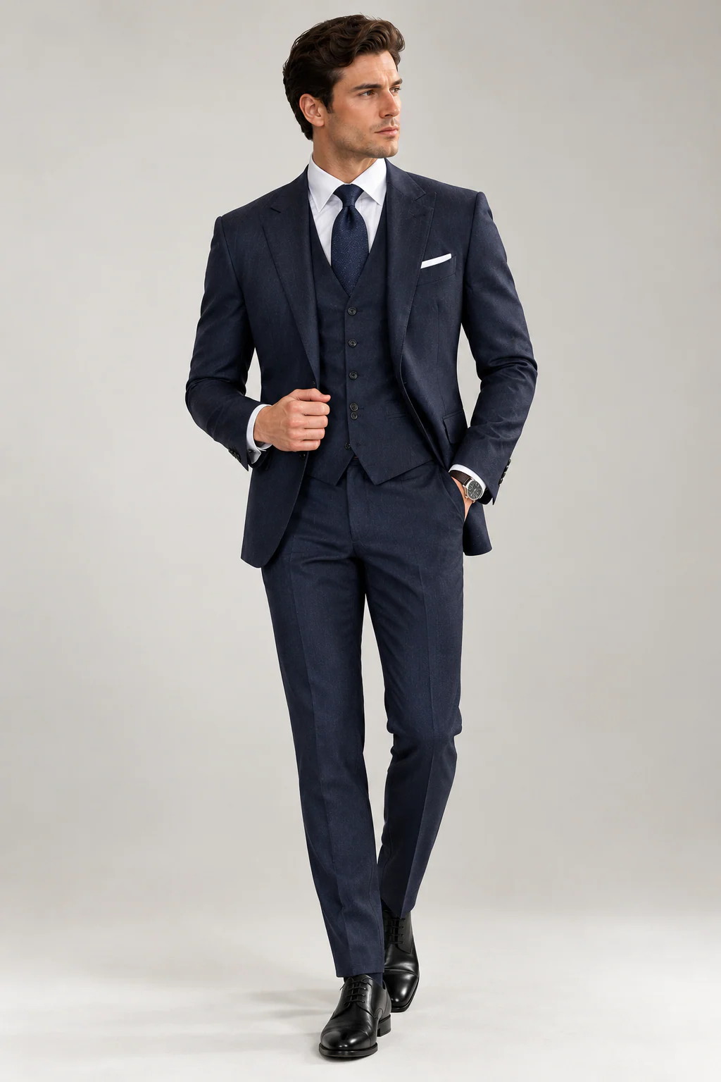 Model wearing a navy three-piece suit with peak lapels